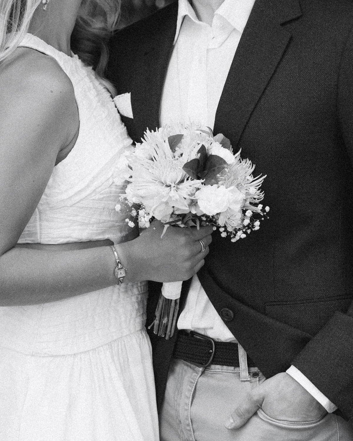 Black and white film close-up of bridal bouquet held by couple during wedding photography at Nara Peace Gardens, Canberra.